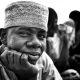 Black and white portrait of a man wearing traditional Zanzibari headwear and expression.