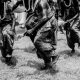 Black and white photo of a traditional dance ceremony outdoors in Ilorin, Nigeria.