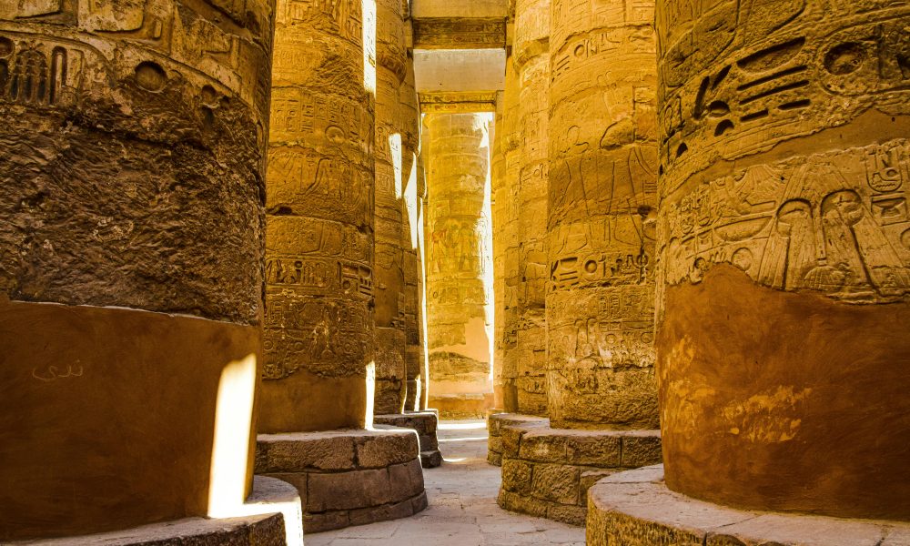 Sunlit ancient columns in the historic Karnak Temple Complex in Luxor, Egypt.