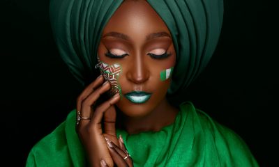 Portrait of a woman in a green turban with face paint, embodying cultural elegance.