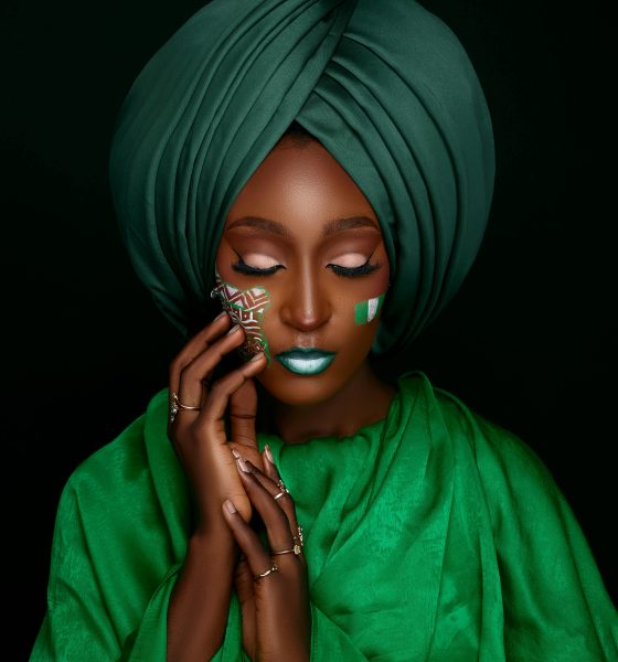 Portrait of a woman in a green turban with face paint, embodying cultural elegance.