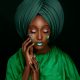 Portrait of a woman in a green turban with face paint, embodying cultural elegance.