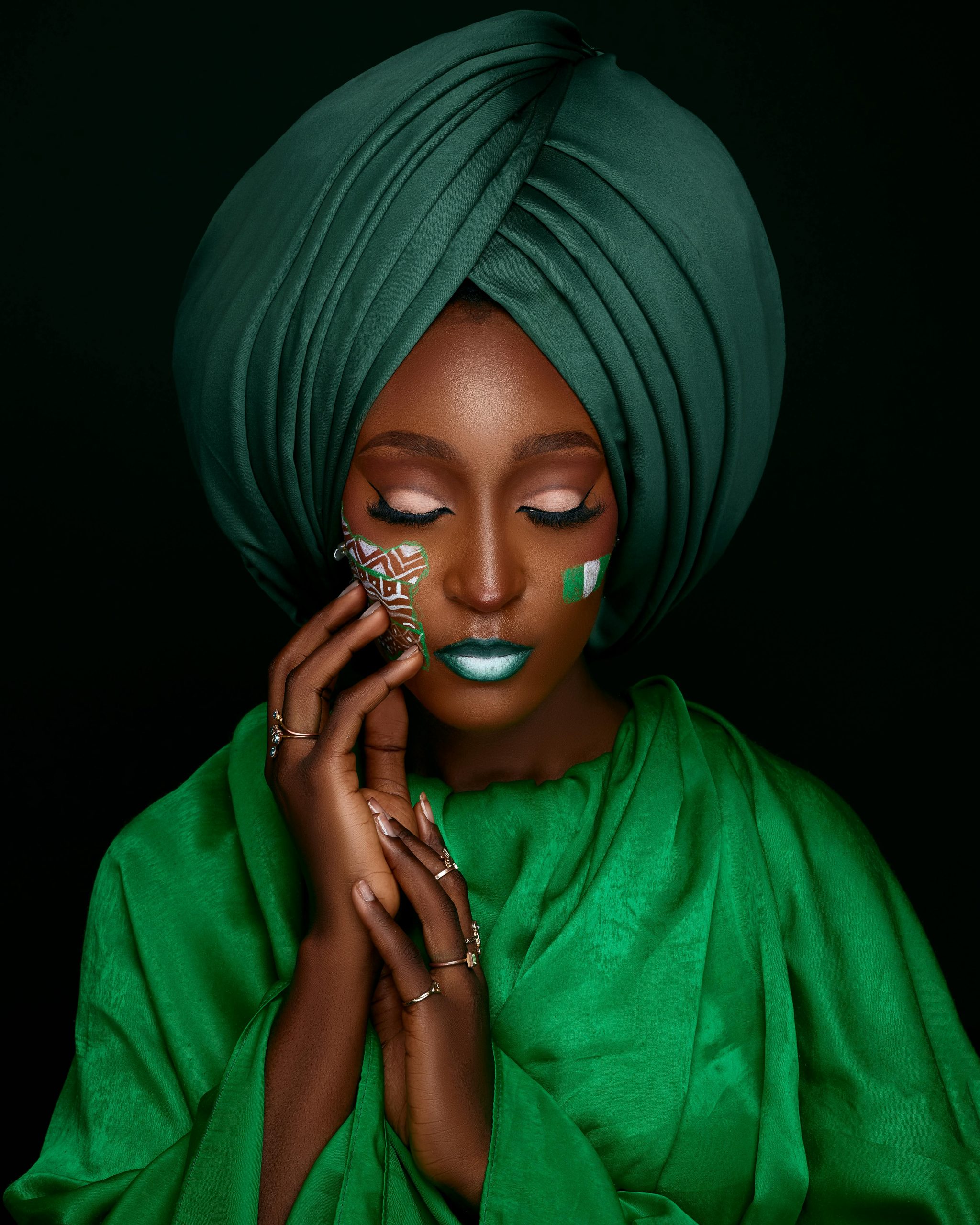 Portrait of a woman in a green turban with face paint, embodying cultural elegance.