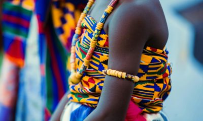 Vibrant traditional Ghanaian attire with beads and kente cloth, highlighting cultural identity.