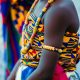 Vibrant traditional Ghanaian attire with beads and kente cloth, highlighting cultural identity.