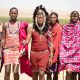 Group of Maasai men in traditional attire walking in the Kenyan landscape.
