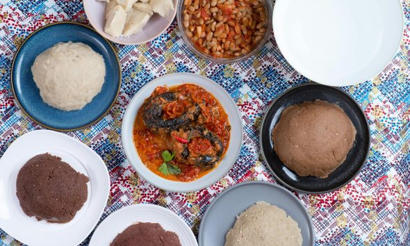 A vibrant flat lay of traditional Burundian dishes including ugali, beans, and vegetable sauce.