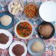 A vibrant flat lay of traditional Burundian dishes including ugali, beans, and vegetable sauce.