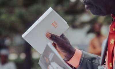 Adult man holding a Holy Bible, participating in an outdoor event, Ibadan, Nigeria.